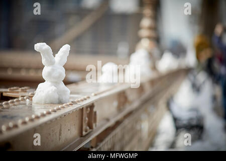Brooklyn in New York City, Easter snow on Brooklyn Bridge sees a snowman replaced with a snow bunny Stock Photo