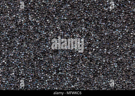 Close-up black  polyurethane foam texture. Rainbow film flares. Abstract black cellular background Stock Photo
