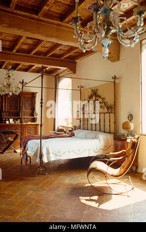 Antique wrought iron four poster bed in rustic bedroom Stock Photo