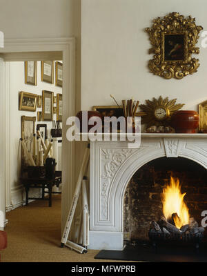 Ornate gilt mirror above fireplace in cream living room with cream ...
