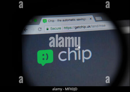 Chip website seen through a magnifying glass. Chip is an app which automatically saves money from your account. Stock Photo