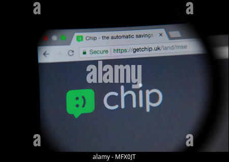 Chip website seen through a magnifying glass. Chip is an app which automatically saves money from your account. Stock Photo