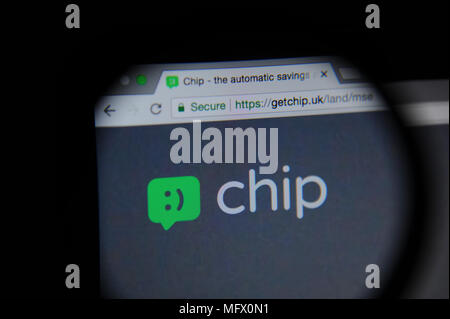 Chip website seen through a magnifying glass. Chip is an app which automatically saves money from your account. Stock Photo