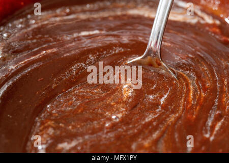 Chocolate brownie mixture stirred with a metal spoon Stock Photo