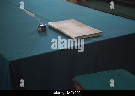 Q the life of a quill pen and book on a cloth covered table in colonial Williamsburg Virginia Stock Photo