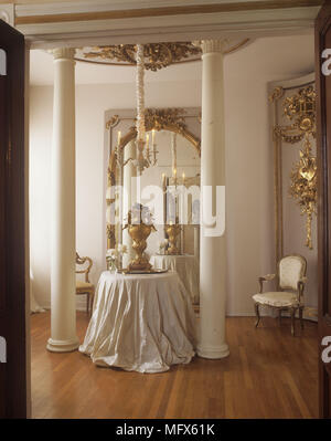 A traditional dining room with a classical theme gilt furniture and elaborately decorated walls. Stock Photo