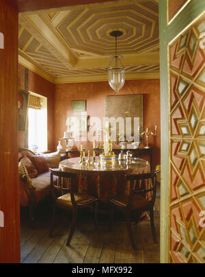 Traditional dining room with terracotta colour walls, wood side cabinet ...