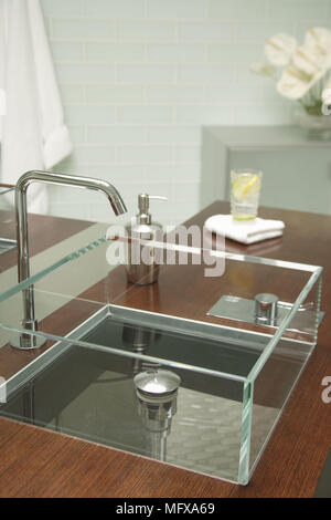 Glass sink on wood shelf in contemporary bathroom Stock Photo