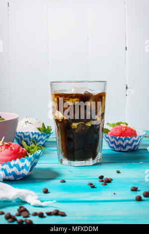 Iced coffee in glass and ice cream on blue wood background. Stock Photo