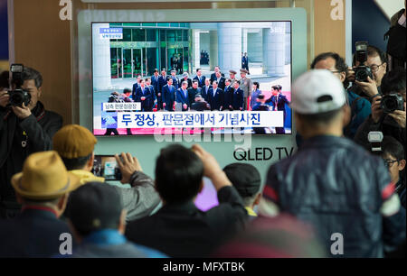Seoul, South Korea. 27th Apr, 2018. People watch news from a screen on the meeting of South Korean President Moon Jae-in and top leader of the Democratic People's Republic of Korea (DPRK) Kim Jong Un, at a railway station in Seoul, South Korea, April 27, 2018. Credit: Lee Sang-ho/Xinhua/Alamy Live News