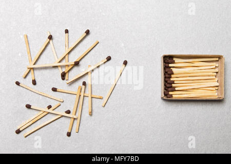 The concept of chaos and order. Chaotic match boxes lying around with the order of stacked matches Stock Photo