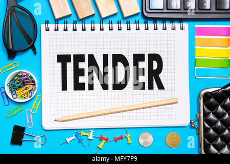 Notes Notebook with a TENDER with the office tools on blue background . Concept TENDER Stock Photo