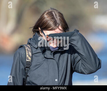 Woman shielding her eyes from the sun Stock Photo