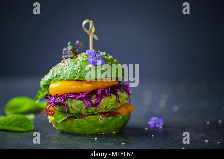 Avocado sandwich with green vegan burger,  roast yellow pepper and pickled red cabbage Stock Photo