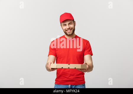 Young handsome man delivering pizza isolated over grey background. Stock Photo