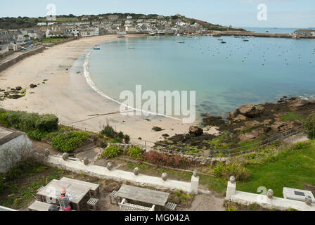 High view point showing Town Beach, St Mary's Harbour and Hugh Town on a sunny Spring morning, with pale blue calm sea and sky. Stock Photo