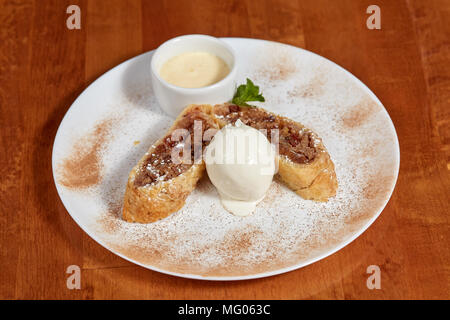 Apple strudel with ice cream scoop on plate, closeup Stock Photo