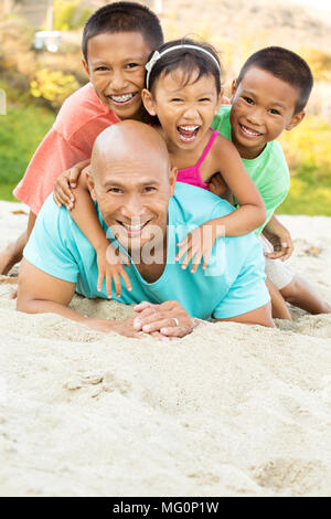 Father playing with his kids on the beach.