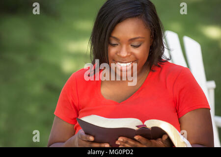 Woman reading outside in the park. Stock Photo