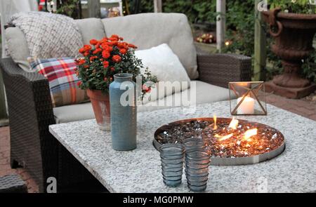 Outdoor seating arrangement around a gas fire pit table in the fall Stock Photo