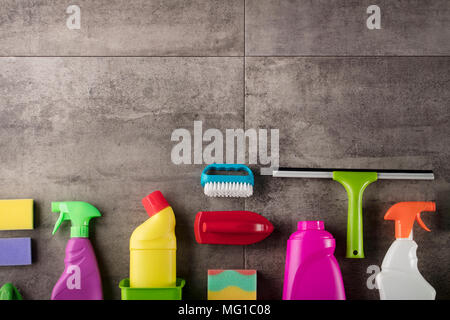 Spring cleaning concept. Colorful cleaning products on gray tiles. Place for typography. Stock Photo