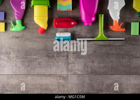 Spring cleaning concept. Colorful cleaning products on gray tiles. Place for typography. Stock Photo