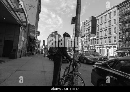 Guy with bike on Manhattan sidewalk Stock Photo