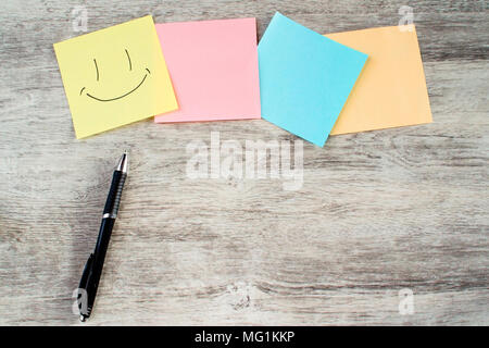 Colored paper stickers and pen on wooden table Stock Photo