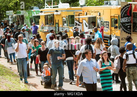 A crowd of people survey their choices and buy meals from food trucks at Grant Park at the Food-o-rama festival on April 16, 2016 in Atlanta, GA. Stock Photo