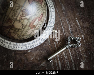 The Antique Key and The Old Wooden Classic World Globe on Old Wooden Background Stock Photo