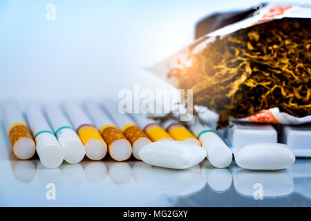 Nicotine chewing gum near pile of cigarettes and tobacco on white background with space. Quit smoking or smoking cessation and lung cancer concept. 31 Stock Photo