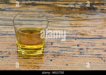 Very old, good, homemade plum brandy in glass on grunge wooden surface with cracks Stock Photo