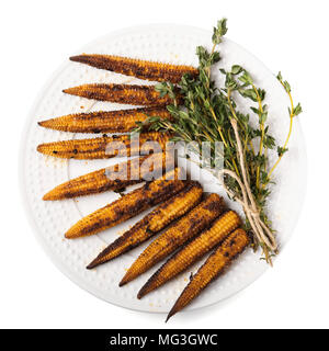 Several fried cobs of young corn with a bunch of thyme isolated on a white background. Concept speed up metabolism, diet for weight loss. Top view, co Stock Photo