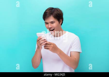 Happy asian man reading funny text on mobile. Stock Photo