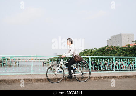 Going everywhere by his bike. Side view of young businessman looking forward while riding on his bicycle Stock Photo