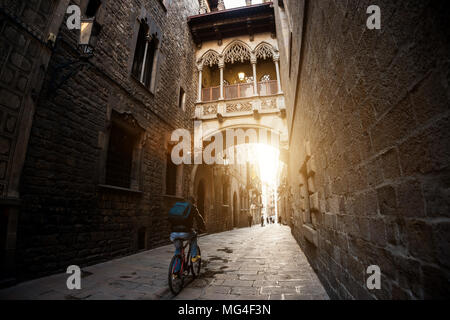 Barcelona people biking bicycle in Barri Gothic Quarter and Bridge of Sighs in Barcelona, Catalonia, Spain. Stock Photo