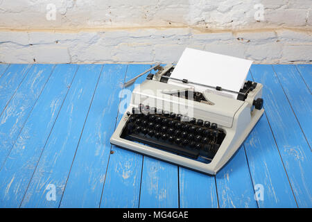 Vintage objects - Old retro Typewriter on a blue wooden background. Stock Photo
