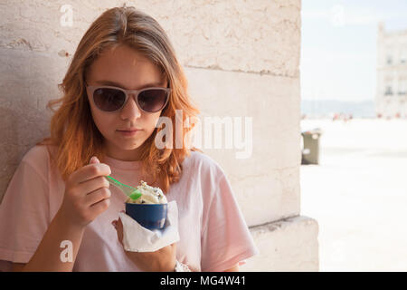 European teenage girl in sunglasses eats ice cream, close up outdoor portrait Stock Photo