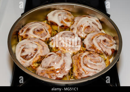 a pan of freshly baked and iced cinnamon rolls Stock Photo