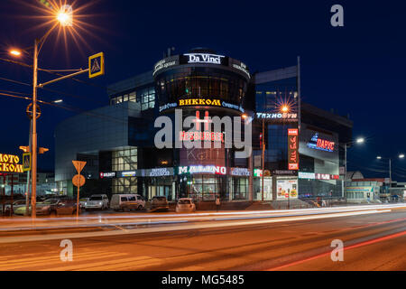 Petropavlovsk City: Night view of building of shopping and entertainment center Sail and blurred traces of car headlights driving on central city road Stock Photo