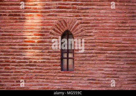 Red bricks wall with one window on the facade of medieval church in Toulouse (France) Stock Photo