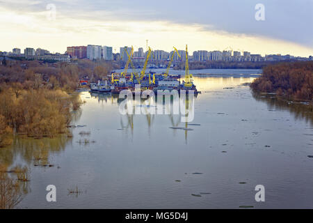 Beginning of navigation on the Irtysh river. Tugboats, floating cranes and ships parked in a backwater Stock Photo