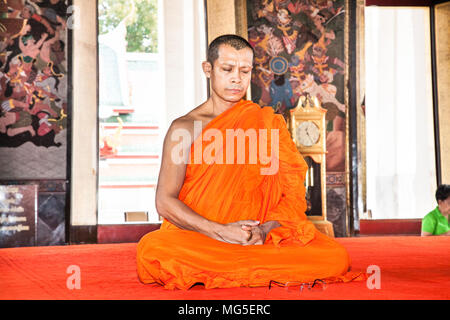 BANGKOK , THAILAND-JAN 19, 2016: The monk in the orange prays in famous Wat Saket (Golden Mount) temple inside on Jan 19, 2016,  Bangkok, Thailand. Stock Photo