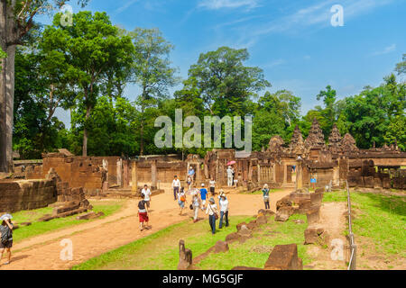 Tourists walking on the causeway in front of the east gopura of the third enclosure in Cambodia's Banteay Srei (Citadel of the Women) temple. Stock Photo