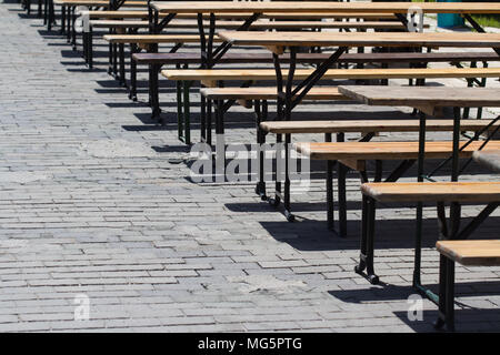 horizontal view row of empty restaurant terrace tables outdoor setting in summer on stone street Stock Photo
