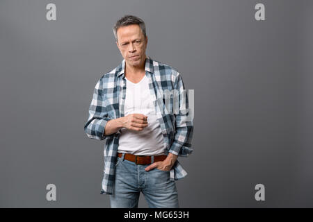 Serious aged man putting hand in the pocket Stock Photo