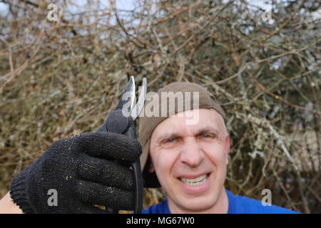 Selective focus shot of a man posing with garden scissors Stock Photo