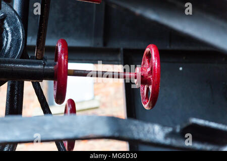 Gloucester, United Kingdom - March 28, 2015: A steam engine driven crane and steering column painted in red in Gloucester Docks. Stock Photo