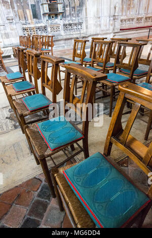 Gloucester, United Kingdom - March 28, 2015: In a backroom in Gloucester Cathedral are wooden chairs with blue seat cushions. Stock Photo