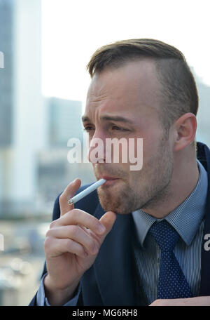 handsome businessman smoking a cigarette Stock Photo